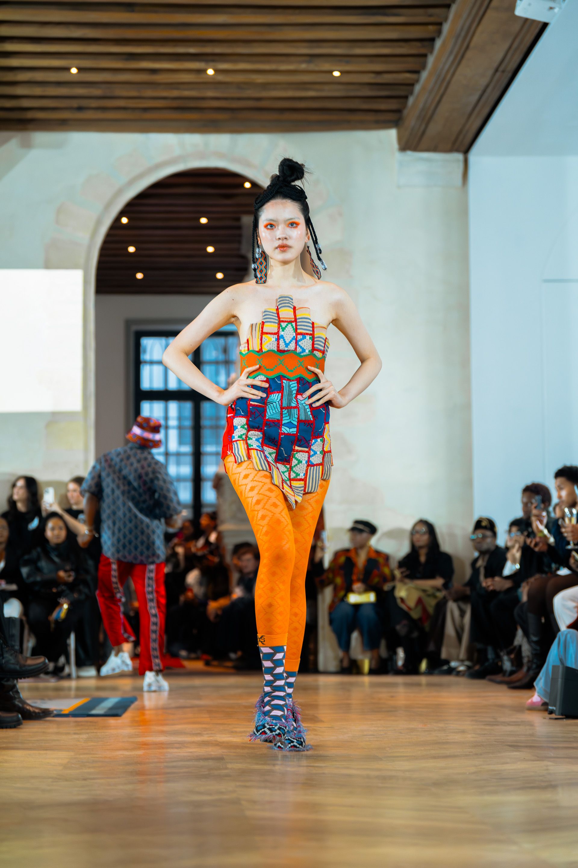 Maxhosa 本季依旧用色彩与图案讲述南非文化：几何民族纹样、鲜艳针织、传统符号与现代街头剪裁交织在一起。运动套装、图腾针织裙与大胆配色让整场秀充满能量与文化表达。每一件衣服像是一段视觉叙事，把非洲传统织物语言转化为当代时装-顽石频道趋势研究